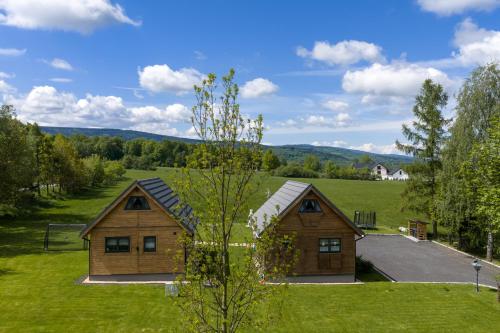 a log cabin in the middle of a green field at Domki Skitnica in Mirsk