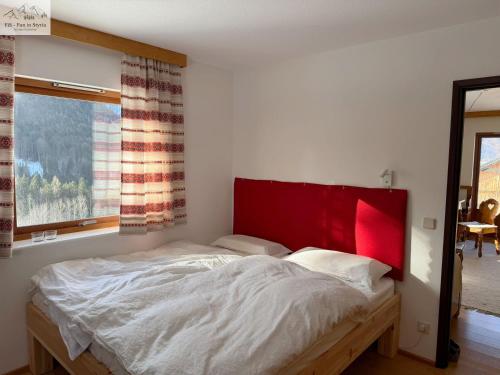a bedroom with a large bed with a red headboard at Ferienhaus Kleinod in Bad Aussee