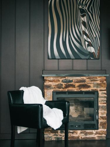a living room with a fireplace and a zebra painting at Alojamiento Luz de Hadas in Sampil