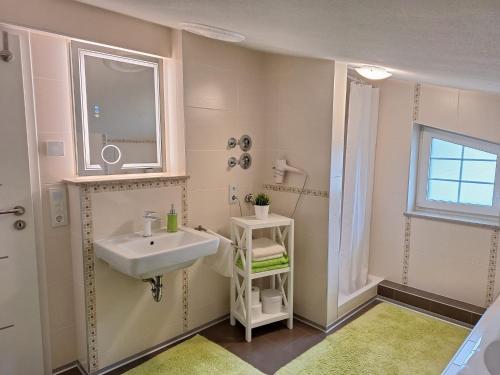 a white bathroom with a sink and a window at modern und gemütlich in Linden