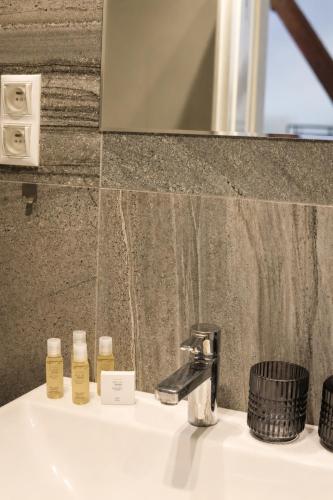 a bathroom sink with two bottles of essential oils on it at ATRIO Apartments 3 in Trenčín