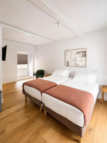 a bedroom with a large bed in a white room at Do Bico Rooms in Camariñas