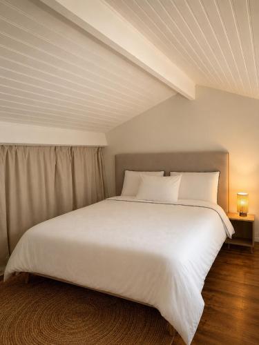a bedroom with a large bed with white sheets and pillows at Maison avec jardin à 5 min à pied de la plage, clim et parking in Royan