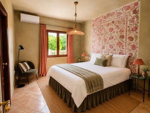 a bedroom with a bed and a chair and a window at Wellness Farm Villa - Monte Valeo in Coín