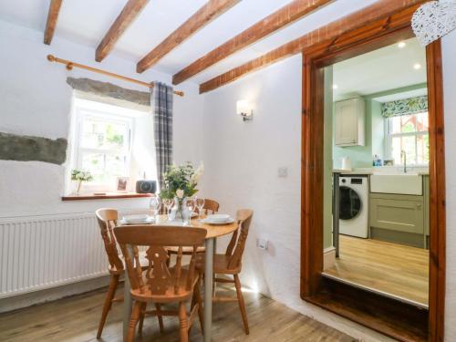 a kitchen and dining room with a table and chairs at Old Chapel House in Llanfairfechan