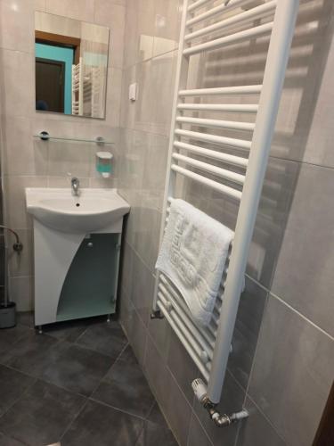 a bathroom with a sink and a white towel at Къща за гости Торлашка среща in Vŭrbovo