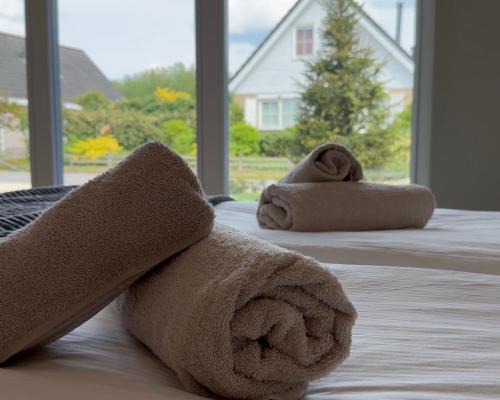 a couple of towels on a bed with a window at Villa Aurelia Spa, Zeewolde 52 in Zeewolde