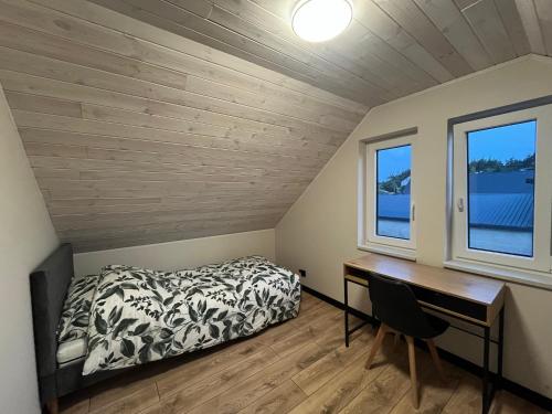 a bedroom with a desk and a bed in a room at Perła prosto z Borów in Cekcyn