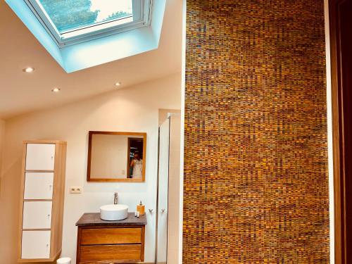 a bathroom with a brick wall with a sink and a mirror at Chez Sophie in Spa