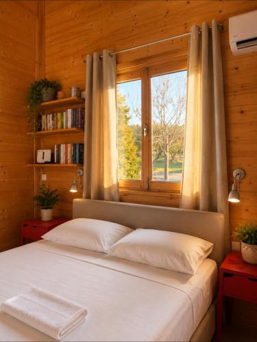 a bedroom with a large bed with a window at Olive Grove in Anavyssos