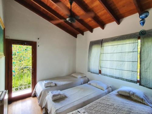 three beds in a room with a window at Un Espacio de Buscadores in Ingeniero Maschwitz
