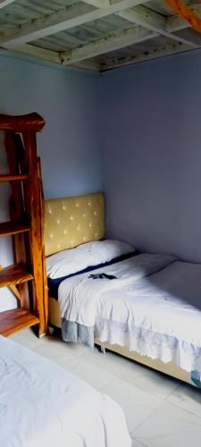 a bedroom with two beds and a book shelf at MATENI's B&B in Naivasha