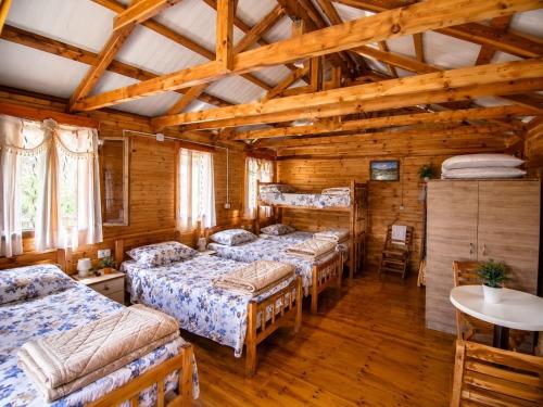 a room with four beds in a wooden cabin at Bujtina Diti in Tropojë