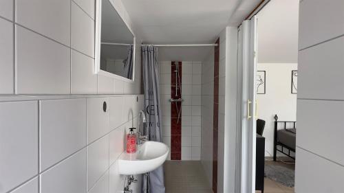 a white bathroom with a sink and a mirror at Agnieszkas Pension in Havelberg