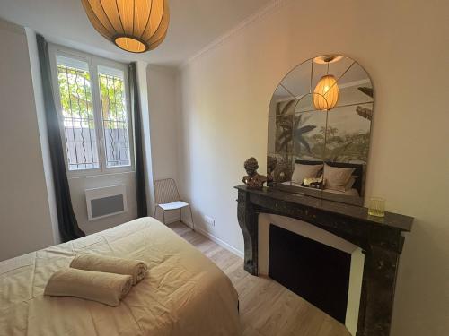 a bedroom with a fireplace and a mirror at Le Jaurès in Brie-Comte-Robert