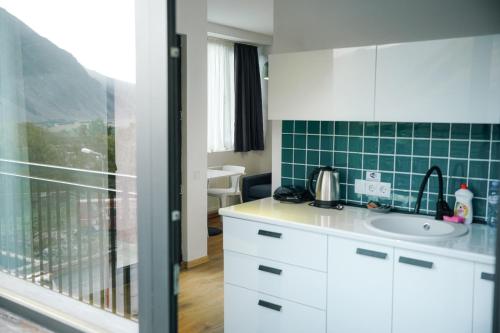 a white kitchen with a sink and a window at Kazbegi Apartments in Kazbegi