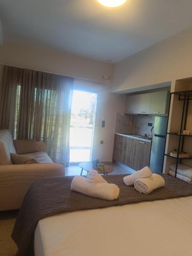 a bedroom with a bed with towels on it at Eden's Garden luxury Studio in Kalamitsi