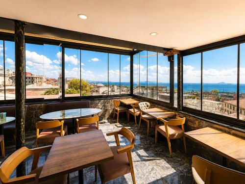 a restaurant with tables and chairs and large windows at G-25219Kaya Royal Hotel By Wsd Hotels Group in Istanbul