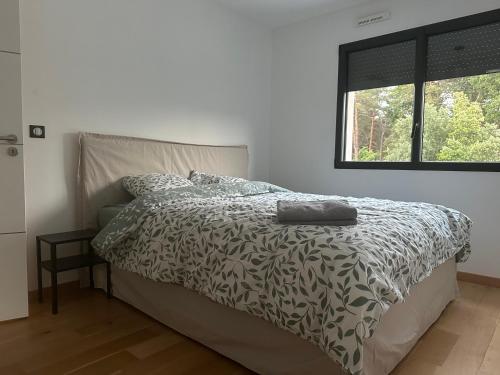 a bedroom with a bed with a comforter and a window at villa des gorges in Vagnas