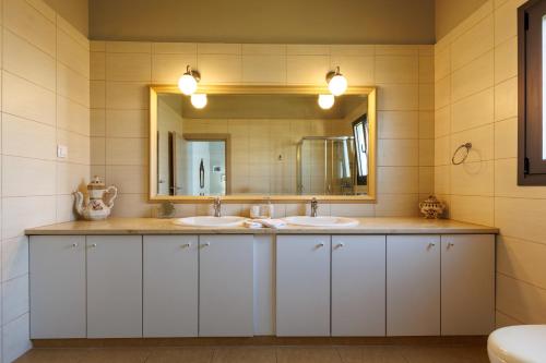 a bathroom with two sinks and a mirror at Villa Katrin in Ialysos