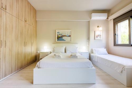 two beds in a room with wooden cabinets at Villa Katrin in Ialysos