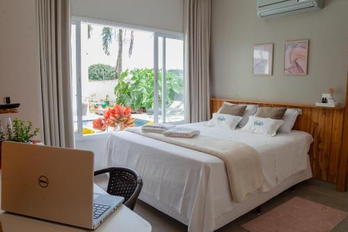 a bedroom with a bed and a laptop on a desk at Hotel e Pousada VIVÁ in Chapada dos Guimarães