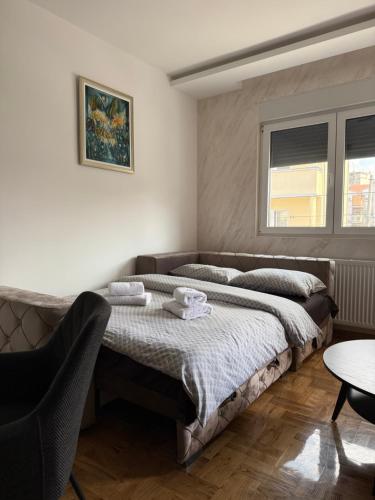 a bedroom with a large bed and a table at PRESTIGE apartman Krusevac in Kruševac