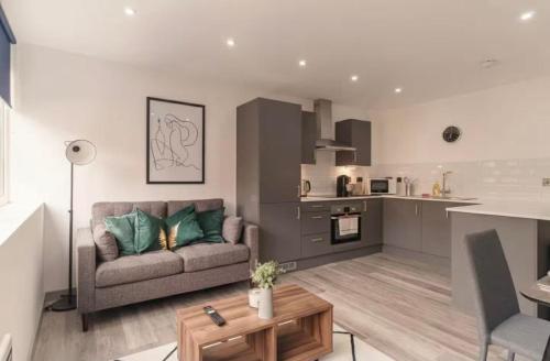 a living room with a couch and a kitchen at Comfortable 1 Bed Apartment Town Centre in Preston
