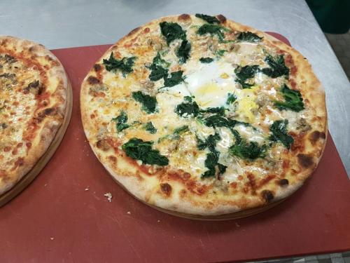 two pizzas sitting on top of a red table at Hotel Bahnhof in Uzwil