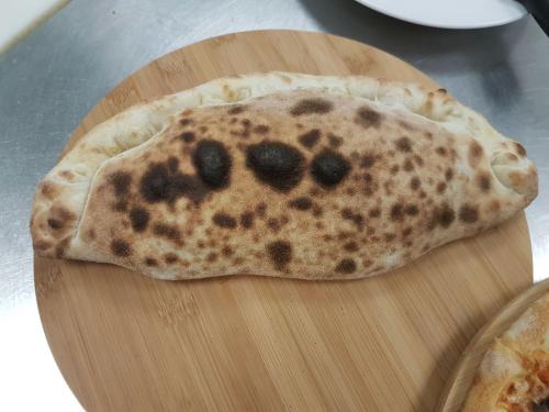 a tortilla with a face on it sitting on a cutting board at Hotel Bahnhof in Uzwil