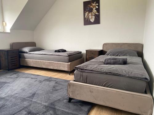 a room with two beds and a rug at Stefans Apartments C - 20 min bis DD Messe und Flughafen inkl Parkplatz in Willich