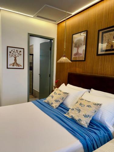 a bedroom with a large bed with blue sheets and pillows at EcoStay Lençóis - apartamento in Lençóis