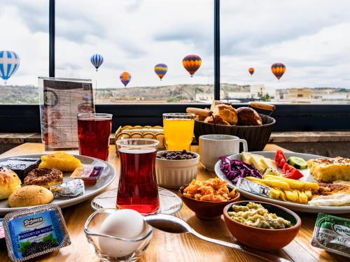 a table with food and drinks and hot air balloons at Ala Stone Hotel - Balloon View Experience in Göreme