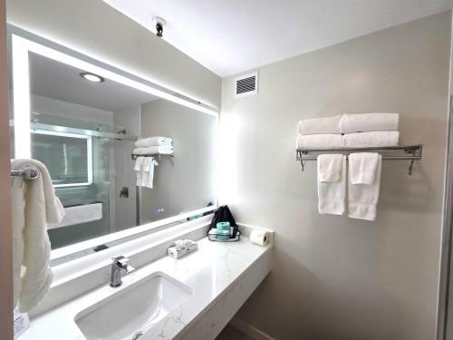 a white bathroom with a sink and a mirror at Fireside Inn & Suites Waterville in Waterville