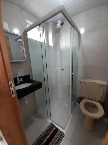 a bathroom with a shower with a toilet and a sink at Kitnet Perequê in Matinhos