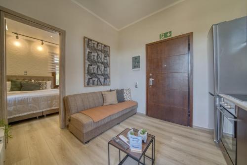 a living room with a couch and a bed at Lotza apartment Votsalo in Vrontádos