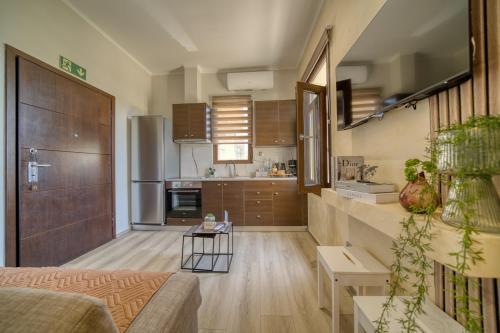 a living room with a couch and a kitchen at Lotza apartment Votsalo in Vrontádos