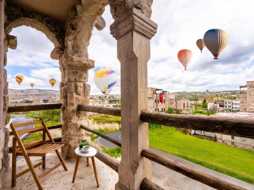 a balcony with hot air balloons flying in the sky at Ala Stone Hotel - Balloon View Experience in Göreme
