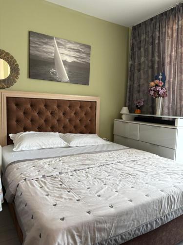 a bedroom with a large bed with a white comforter at ADMIRAL PLASA studiyo-25C in Sunny Beach