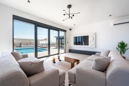 a living room with a couch and a tv and a pool at Krimovica Villas in Budva