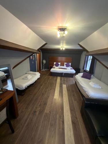 ein großes Zimmer mit zwei Betten in einem Zimmer in der Unterkunft Bennetts Hotel in Long Eaton