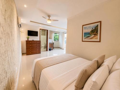 a bedroom with a large bed and a television at Sintonia com o Mar in Angra dos Reis