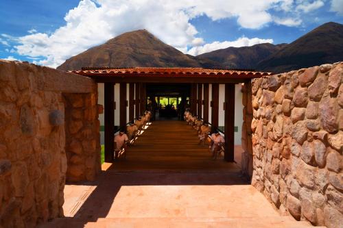 a group of animals walking down a hallway with mountains at RUSTICA HOTELES CUSCO Urubamba in Urubamba
