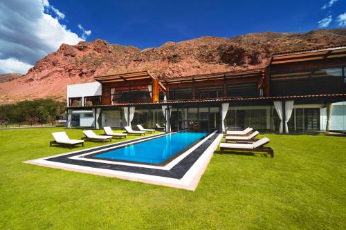 a house with a swimming pool with lounge chairs at RUSTICA HOTELES CUSCO Urubamba in Urubamba