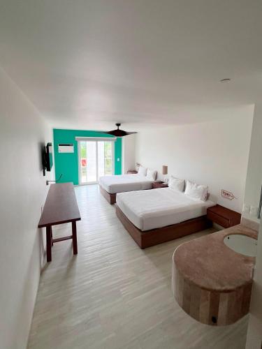 a hotel room with two beds and a table at Hotel Tuki Tulum in Tulum