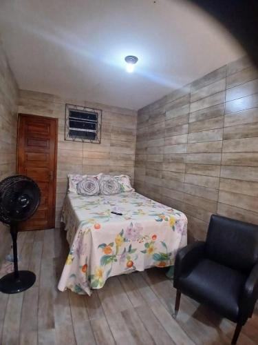 a bedroom with a bed and a chair at Estúdio moderno com cozinha america in Ilhéus