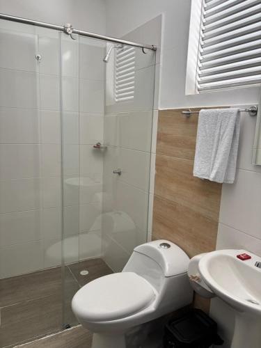 a bathroom with a toilet and a glass shower at Hotel Logistico in Santa Marta