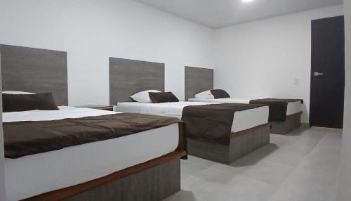 a room with three beds in a room at Hotel Logistico in Santa Marta