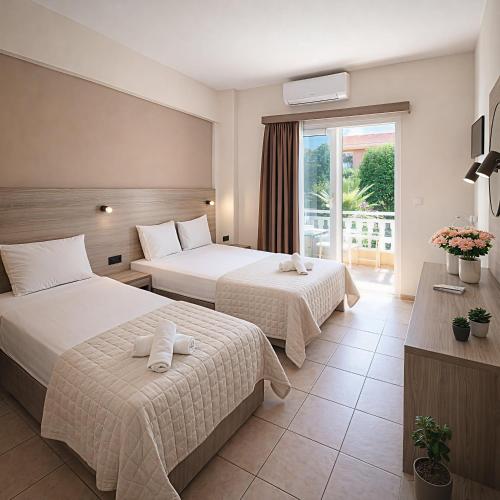 a hotel room with two beds and a balcony at John & Eve Hotel in Paralia Katerinis