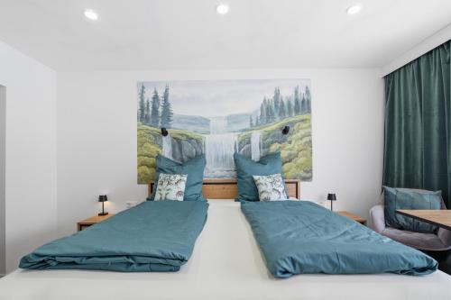 a bedroom with a large bed with blue pillows at Schwarzwald Ledi - Bed & Breakfast Feldberg in Feldberg